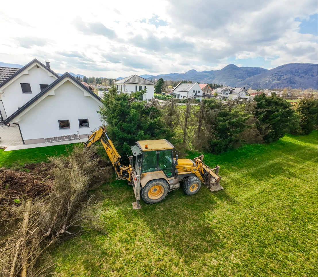 Tractor clearing trees near houses